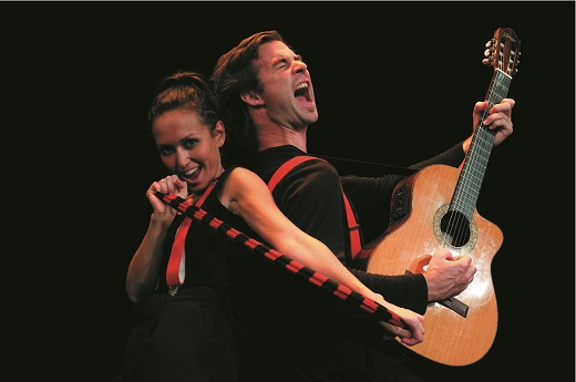 La comédienne et le comédien sont dos à dos et chantent à tue-tête, lui tenant une guitare