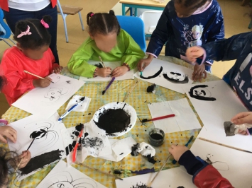 Kotimi apprend le dessin à l'encre de chine à des enfants